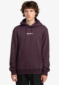 Sudadera con capucha morada, con bolsillo tipo canguro y cordones, que presenta un logo beige en el pecho y puños y dobladillo acanalados.
