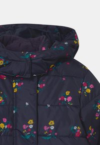 Giacca puffer blu navy con stampe floreali colorate in rosa, giallo e bianco. Presenta un colletto alto e un morbido rivestimento interno.