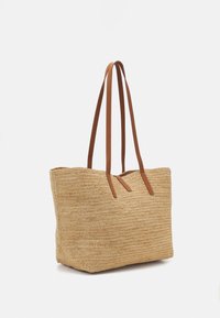 Punotusta olkikassista valmistettu suorakaiteen muotoinen laukku, beigen värinen ja ruskeilla nahkaisilla olkahihnoilla. Pintakuvioitu vaakasuorilla viivoilla.