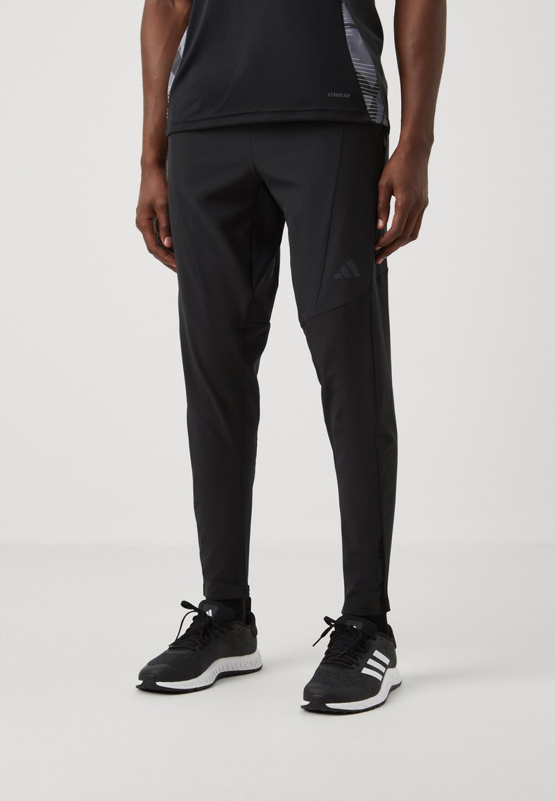Zwarte sportbroek gemaakt van een lichtgewicht materiaal met een slim fit, met subtiele branding en een taps toelopend ontwerp voor ventilatie.