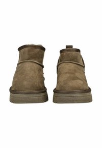 Botas de tobillo de ante marrón con una textura suave, punta redonda, suela de goma baja y costuras decorativas alrededor del collar y la media suela.