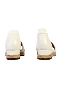 Sandales en cuir blanc avec un talon fermé, des côtés ouverts et un talon bas de style espadrille tissé. Texture lisse et design neutre.