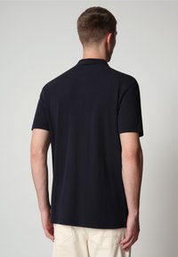 Polo bleu marine foncé à manches courtes, en coton lisse, col classique et coupe droite à l'ourlet. Design minimaliste sans motifs.