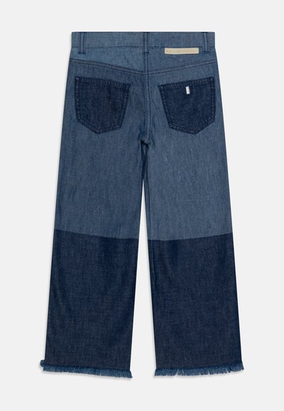 Denim široke hlače z barvno blokado v svetlo in temno modri barvi, z raztrganim robom in dvema zadnjima žepoma.