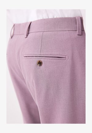 Vaaleanvioletit housut, jotka on valmistettu teksturoidusta kankaasta. Housuissa on takatasku, jossa on ruskea nappi, sekä vyölenkit. Housut on kuvattu sivukulmasta.