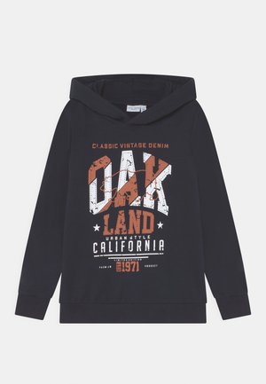 Černá mikina s kapucí vyrobená z bavlny, s grafickým potiskem v bílé a oranžové barvě, na kterém je napsáno "OAK LAND CALIFORNIA 1971" ve vintage stylu.