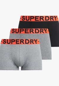 Tre paia di boxer in grigio, grigio a righe e nero. Ognuno presenta una cintura arancione con la scritta "SUPERDRY" stampata in modo ben visibile.