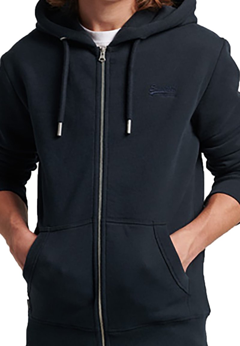 Felpa con cappuccio navy con zip in morbido misto cotone; presenta cappuccio con coulisse, tasche frontali e logo in rilievo sul petto.