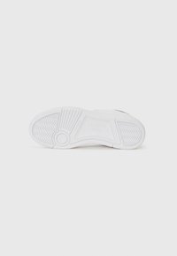 White sneaker sole with textured grip pattern, featuring a prominent grooved design and embossed brand logo. Smooth, rubber material.