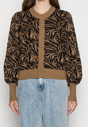 Brun og sort strikket cardigan med tigerstribet mønster, ribbede manchetter og knaplukning, parret med lyseblå jeans.