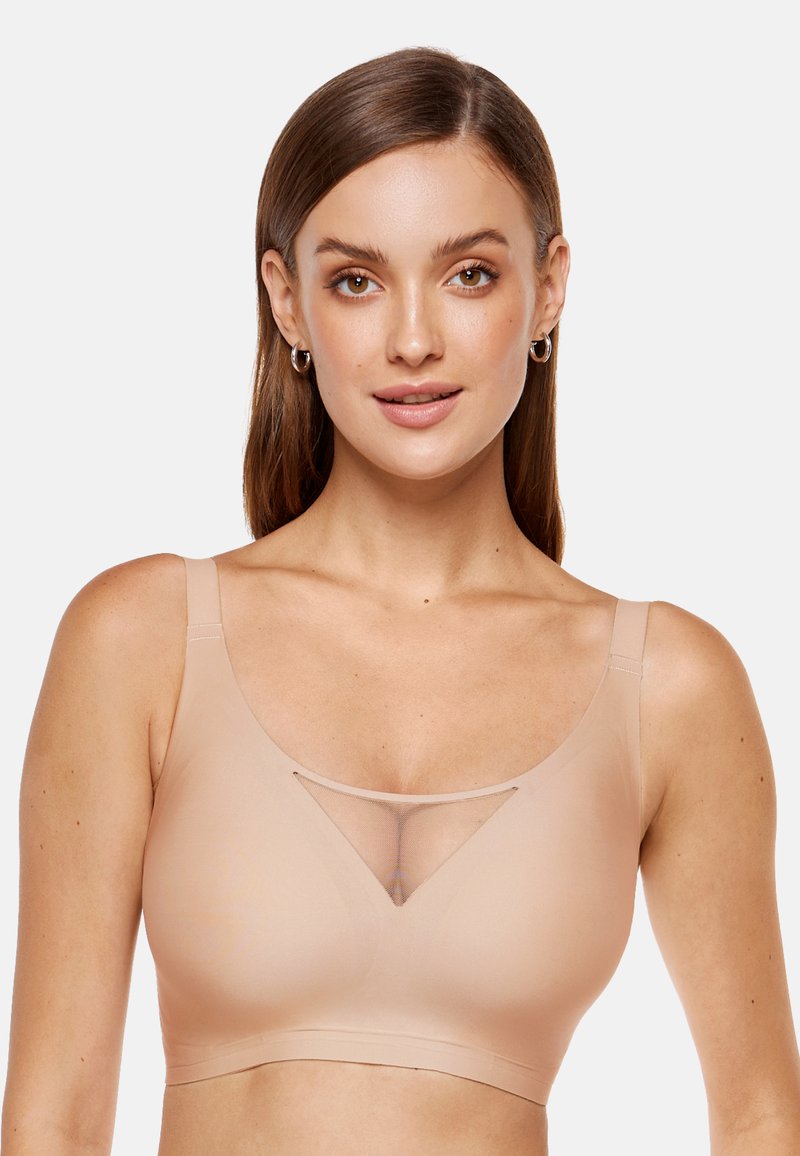 Beżowy bezprzewodowy biustonosz z szerokimi ramiączkami, gładkim materiałem, trójkątnym wycięciem z siateczki na środku i bezszwowym wzorem.