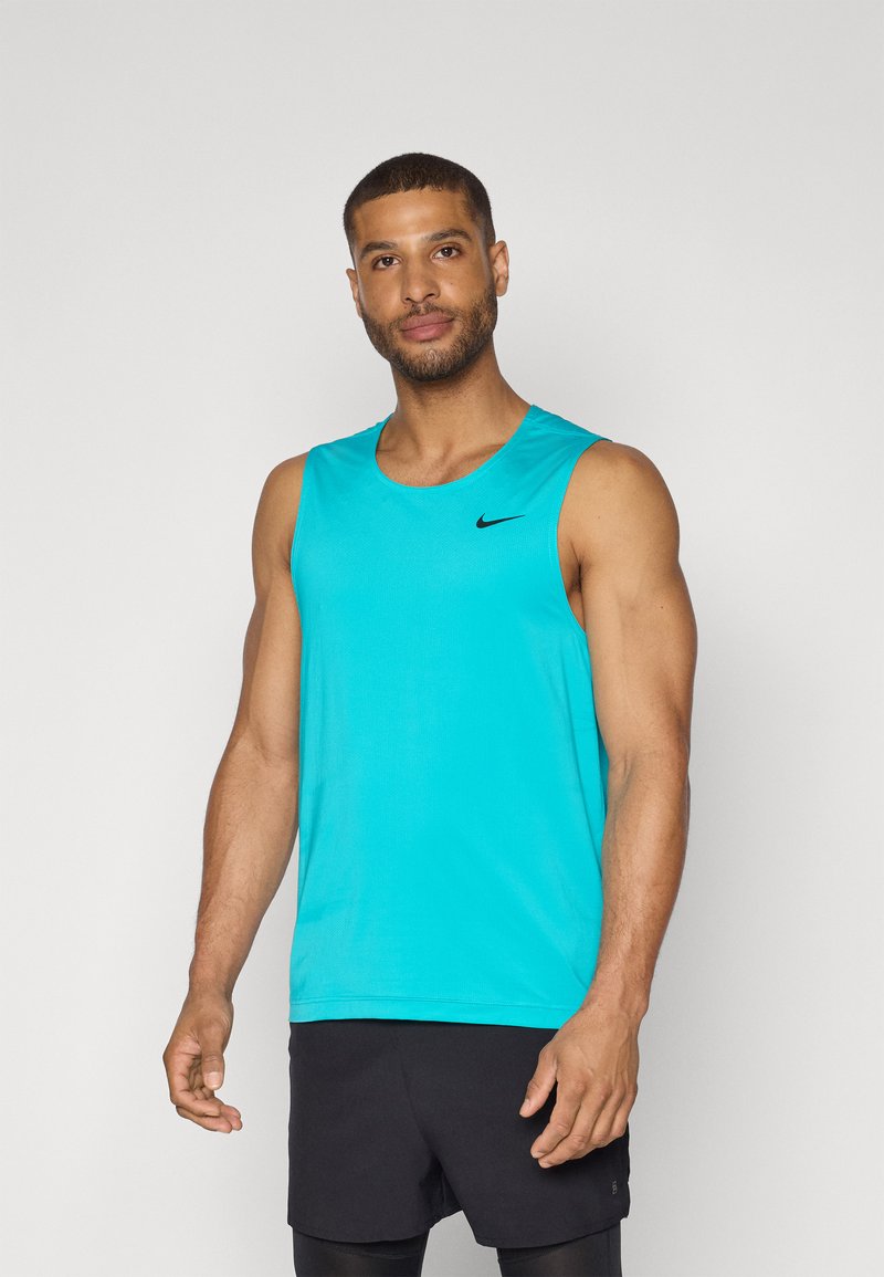 Turkoosi urheilu-toppi, jossa on pyöreä pääntie ja musta Nike-logo rinnassa. Kangas vaikuttaa kevyeltä ja hengittävältä.