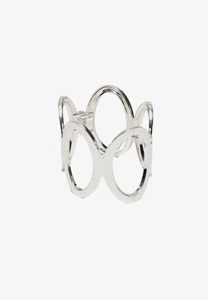 Hopeinen rannekoru, jonka suuret ovaalinmuotoiset avoimet lenkit on yhdistetty jatkuvaksi ympyränmuotoiseksi nauhaksi valkoisella taustalla.