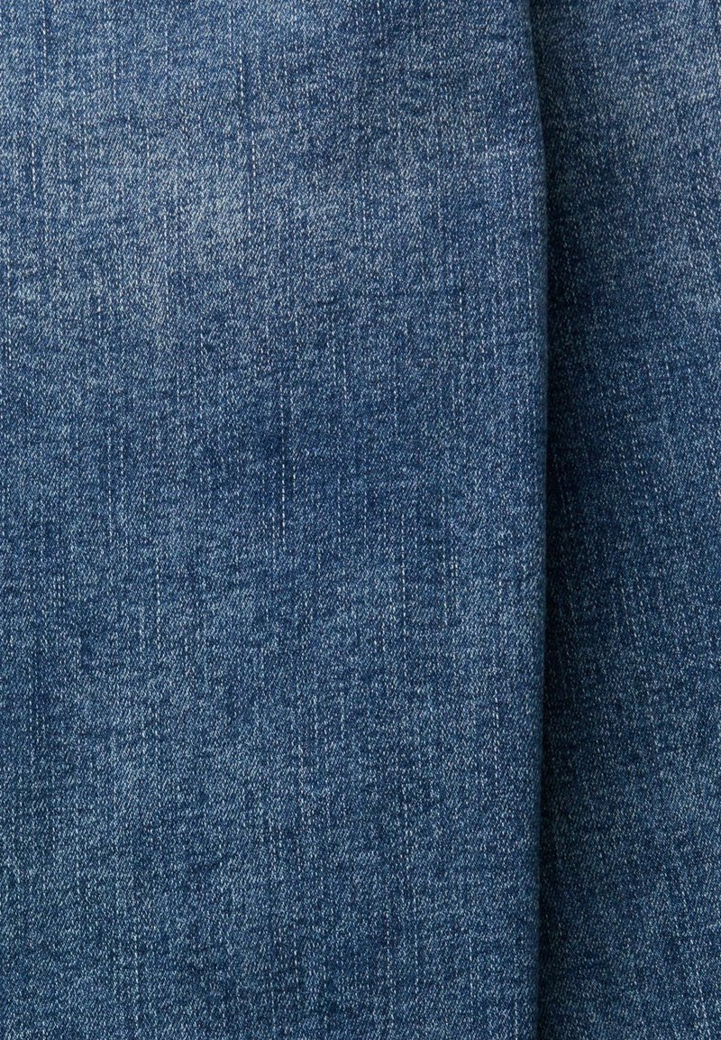 Blaue Denim-Stoff mit sichtbarem diagonalen Webmuster und leichten Variationen in den Blautönen, vertikal auf der rechten Seite gefaltet.