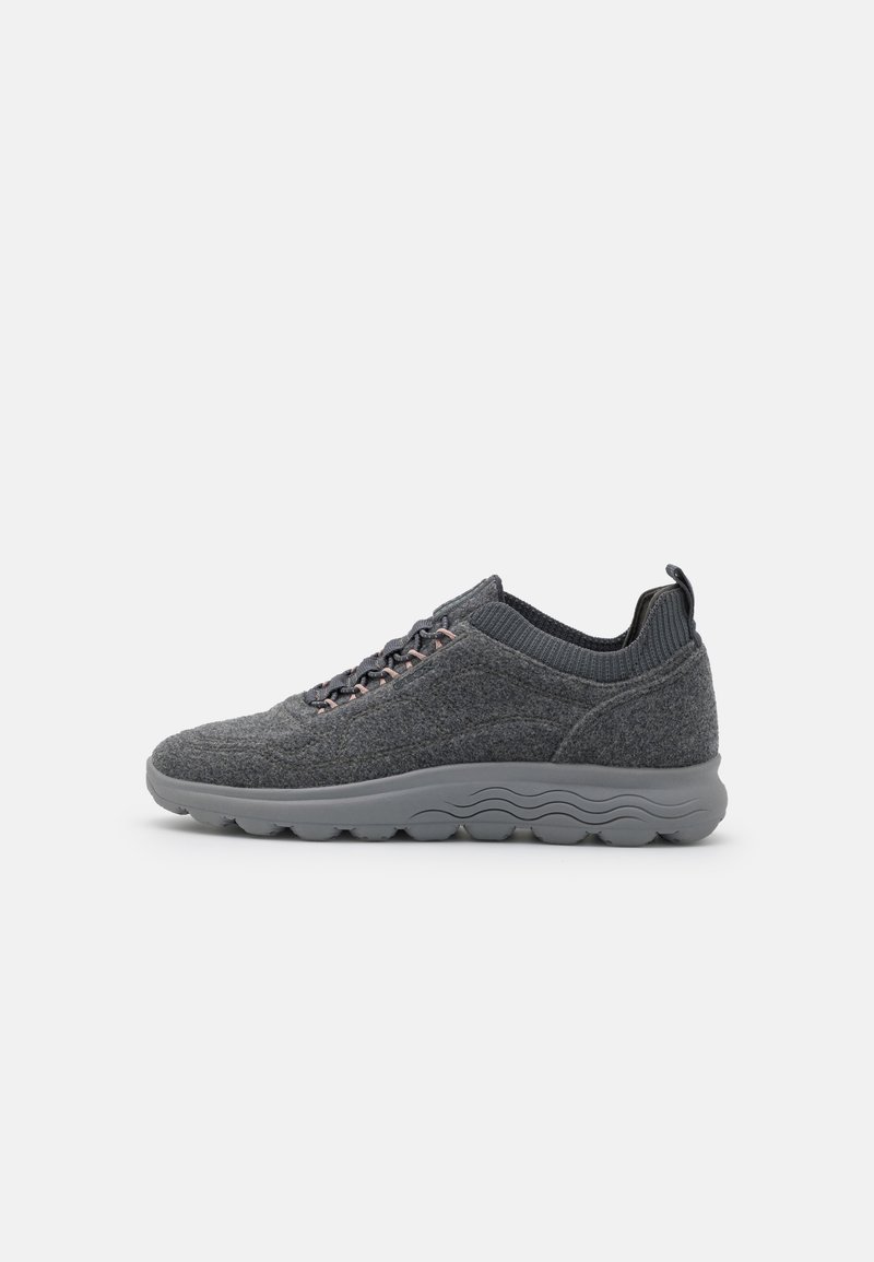 Chaussure de sport grise avec une tige texturée, dotée d'un col en tricot et d'accents roses. La semelle extérieure est grise avec un design ondulé pour une meilleure adhérence.