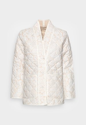 Quilted white jacket with beige floral pattern, front buttons, two large front pockets, and a shawl collar.