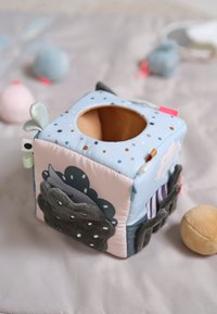 Soft fabric activity cube featuring a colorful polka dot design, a round opening on top, and textured accents in various colors.