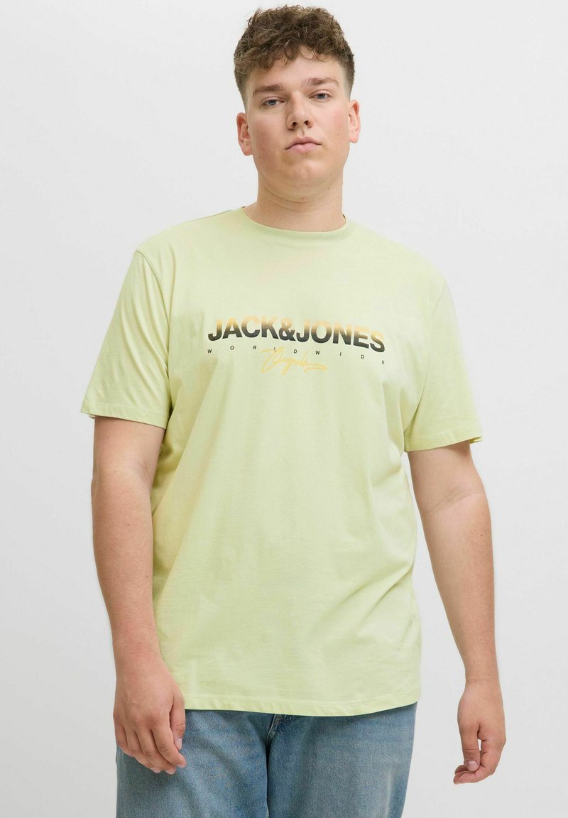 Svijetlozelena majica kratkih rukava od pamuka, s crno-narančastim grafičkim tiskom koji prikazuje natpis "JACK&JONES" na prednjoj strani.