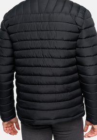 Schwarze Steppjacke mit horizontaler Rautennarbung. Hergestellt aus leichtem, glattem Material, mit Stehkragen und taillierten Ärmeln.