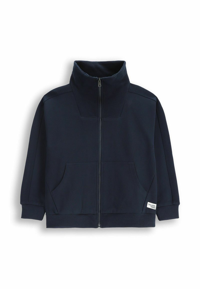 Granatowa kurtka na zamek błyskawiczny z wysokim kołnierzem, żebrowanymi akcentami na ramionach, dwoma przednimi kieszeniami oraz elastycznymi mankietami i dołem. Wykonana z miękkiego materiału.