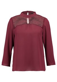 Burgundy blus med långa ärmar, hög hals och spetsdetaljer framtill. Slätt tyg med avslappnad passform och nyckelhålsöppning bak.