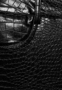 Zwart leermateriaal met een gestructureerd, krokodillenleren patroon. Heeft een pocket met stikseldetails en een glanzende afwerking.