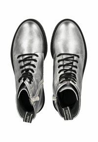 Bottines métalliques argentées avec des lacets noirs et une fermeture éclair sur le côté. Elles présentent une texture lisse et un design à bout rond.