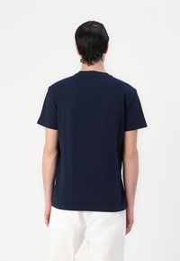 Navy blue cotton t-shirt with short sleeves, crew neckline, and a plain back design. Smooth texture with no visible patterns or accents.