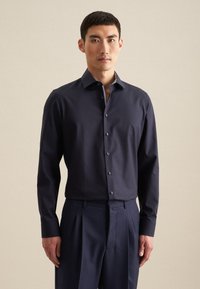 Marineblauw overhemd met knopen en een gestructureerde kraag, voorzien van een subtiele gestreepte afwerking aan de binnenkant. Lange mouwen en een slim fit, gecombineerd met bijpassende broek.