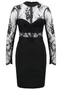 Svart klänning med långa spetsärmar, genomskinlig spetskjol, strukturerad kupdetalj och åtsittande silhuett. Dragkedjestängning i ryggen och spetsdetaljer.