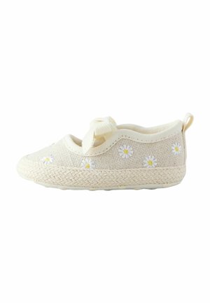 Chaussure bébé en tissu couleur crème avec des marguerites blanches et jaunes brodées et un nœud doux sur le dessus, avec une semelle texturée.