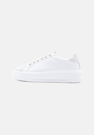 White low-top sneaker with thick sole, heart-shaped eyelets, and subtle embellishments on the toe area, shown in side profile.