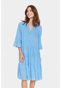 Rochie albastră dintr-un material ușor, cu decolteu în V, mâneci flared de trei sferturi și modele cu puncte albe; design stratificat până la genunchi.