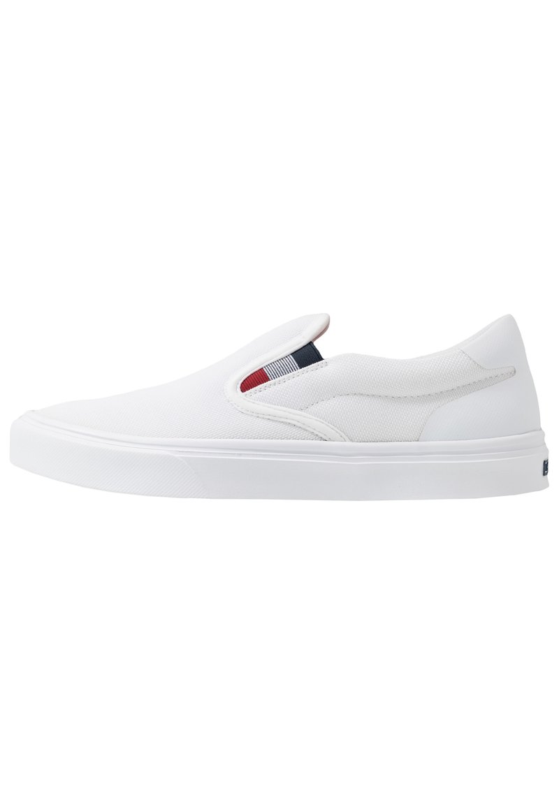 Weiße Slip-On-Canvas-Schuhe mit einer strukturierten Oberseite, elastischen Einsätzen und einer soliden Gummisohle. Akzentuiert mit einem kleinen farbigen Etikett.