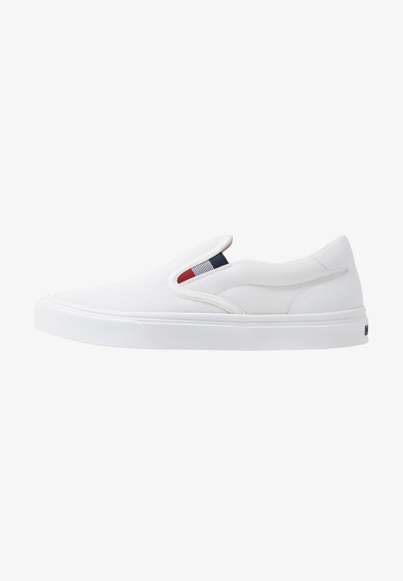 Weiße Slip-On-Canvas-Schuhe mit einer strukturierten Oberseite, elastischen Einsätzen und einer soliden Gummisohle. Akzentuiert mit einem kleinen farbigen Etikett.