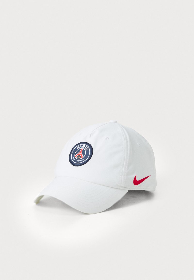 Biela baseballová čiapka s okrúhlym logom Paris Saint-Germain vpredu a červeným Nike swoosh na boku. Textúra látky je hladká.