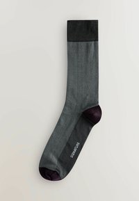 Skarpetki w szarym wzorze jodełki z czarną górną częścią i ciemnofioletowym palcem oraz piętą. Posiadają gładką teksturę i żebrowany ściągacz.
