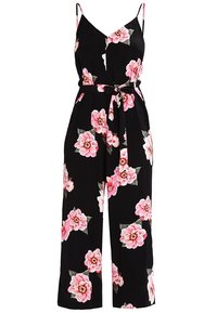 Combinaison noire à motif floral avec des fleurs roses, bretelles spaghetti réglables, ceinture à nouer à la taille, et coupe à jambes larges. Texture de tissu lisse.