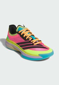 Chaussure de sport colorée avec une tige en mesh rose, verte et noire, des lacets orange, et une semelle rembourrée multicolore.