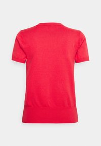 Punainen lyhythihainen paita, joka on valmistettu kevyestä neulostyypistä. Ominaisuuksiin kuuluu yksinkertainen ja selkeä muotoilu pyöreällä kaula-aukolla ja ribbireunalla.