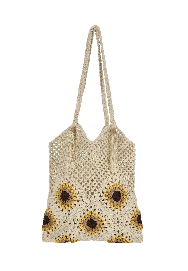 Hæklet nettaske i cremefarve med solsikke-mønstre i gult og brunt. Har flettede håndtag og kvaster, der fremhæver det åbne vævedesign.