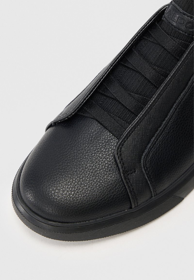 Schwarze Ledersneaker mit strukturiertem Finish, elastischem Schnürdesign, verstärkter Zehenkappe und Gummisohle. Verfügt über einen nahtlosen, sportlichen Look.