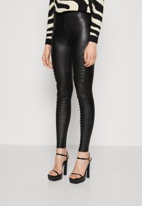 Svarta fejk läder leggings med en slank, åtsittande design och ribbad detaljer på sidorna. Matchas med svarta högklackade sandaler.