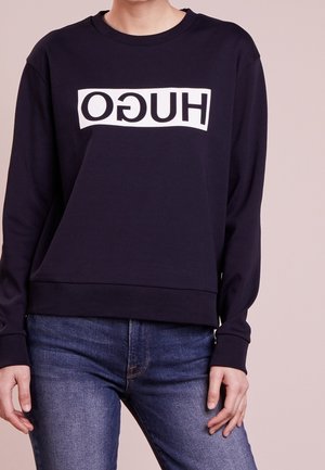 Sudadera de color azul marino con mangas largas, que presenta un logo horizontal en blanco "HUGO" en el pecho y un corte relajado con puños acanalados.