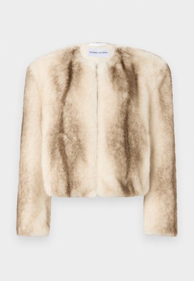 Kreemja ja heledate pruunide toonidega vale karva lühike jakk, millel on ümar kaelus, pikad varrukad ja eesne lukuga sulgemine.