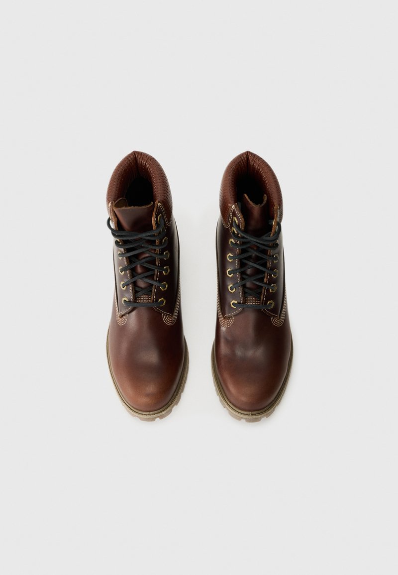 Pair of brown leather lace-up boots with padded collars and beige soles, shown from above on a white background.