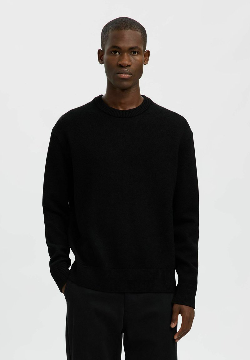 Černý pletený svetr s kulatým výstřihem, dlouhými rukávy a žebrovanými manžetami a lemem. Hladká textura a volný střih.