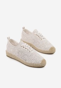 Chaussures blanches à lacets avec des motifs floraux délicats, dotées d'une semelle en jute tressé et de bouts renforcés. Texture de tissu douce et design léger.