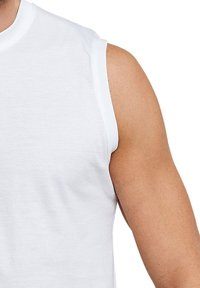 Bez rękawów biały bawełnowy t-shirt z okrągłym dekoltem i czystymi brzegami, ukazujący fragment opalonego ramienia i barku.