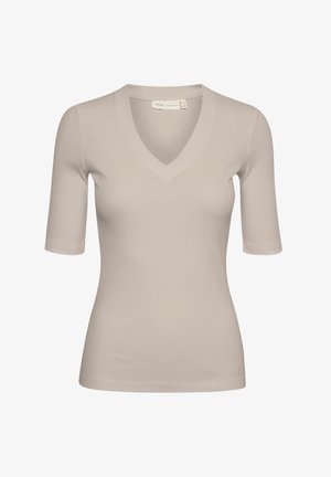 Beige ribbad topp med kort ärm och V-ringning, med en kroppsnära passform och en subtil logotyp vid fållen. Slät textur, minimalistisk design.